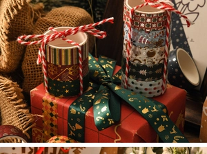 Close-up of Christmas washi tape set with gold foil details on a red festive gift box