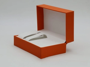 Macro shot of the orange PU leather watch box interior with white lining and holders