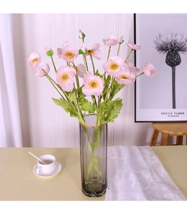 Pink silk corn poppy flowers in gray transparent glass vase for home interior decor