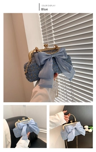 Détail du sac de soirée en tweed bleu avec grand nœud en organza et chaîne dorée