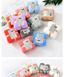 Close-up of colorful coral fleece towels with elegant gift ribbon and grey band packaging