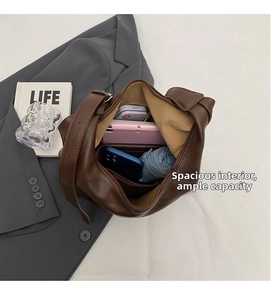 Top-down macro view showing spacious interior of brown leather tote bag with essentials