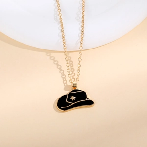 Close-up of golden necklace with a black enamel cowboy hat pendant featuring a gold star