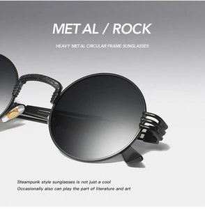 Close-up of steampunk round metal sunglasses with intricate floral engraving on temples