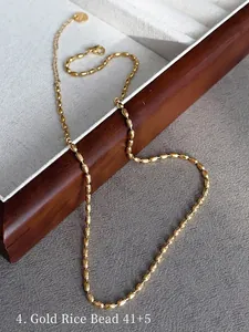 Detail of 41+5cm gold beaded rice chain necklace in titanium steel on a luxury tray