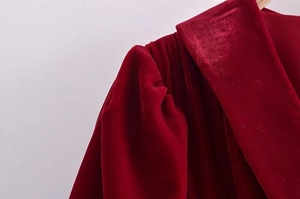 Gros plan du velours rouge montrant les détails des plis sur l'épaule