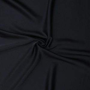 Close-up detail of soft black fabric texture and natural drapes on the sleeveless top