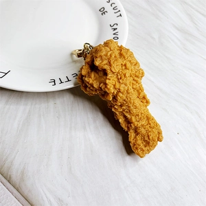 Detail van gebakken kippenpoot sleutelhanger met hars textuur en gouden ring