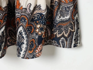 Details des gestuften Saums mit Paisley-Muster und feiner Naht am Sommerkleid