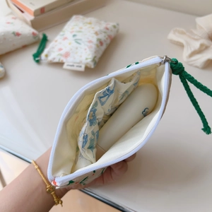 Close-up of floral cotton pouch interior with elastic pocket and green pull cord