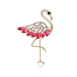 Golden flamingo brooch with sparkling rhinestones and pink gems on white background