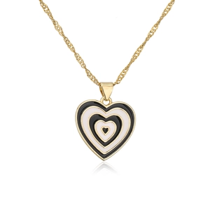 Macro shot of 18K gold plated heart pendant with black and pink enamel detail