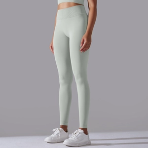 Detail of high-waist ribbed tummy control yoga leggings in light green seamless knit fabric
