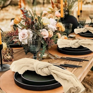 Close-up of beige cheesecloth table napkin knotted on a plate for wedding decor