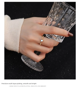 Detailed close-up of a gold-plated moonstone ring with intricate metallic grain and small crystals