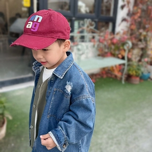 Detail of burgundy baseball cap with white letter embroidery paired with denim jacket