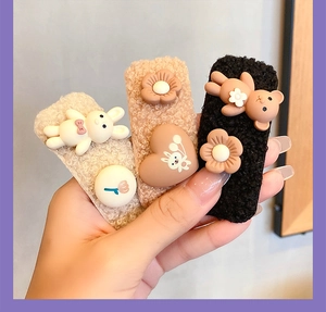 Close-up of plush bear and rabbit cartoon hair clips in beige, brown and black