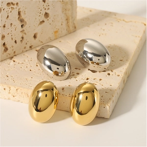 Polished oval bean stud earrings in 18k gold and silver finish on stone display