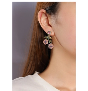 Close-up of pink and purple floral earrings with colorful zircon stones on model