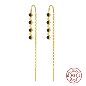 Detailed view of long gold tassel earrings with black stones and 925 silver hallmark