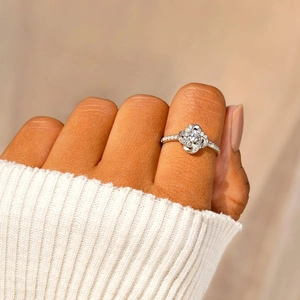 Close-up of s925 silver clover ring with zircon worn on index finger with knit cuff