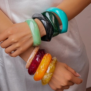 Detail showing stacked resin bangles with marble texture in vibrant multi-color shades