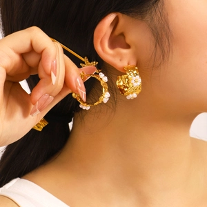 Gold stainless steel C-shape earrings with pearls shown on model in a studio setting