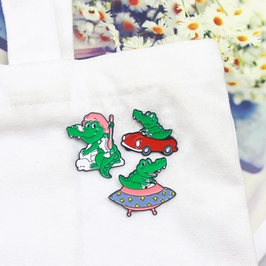 Cartoon crocodile enamel pin set featuring bathing, driving, and flying saucer scenes