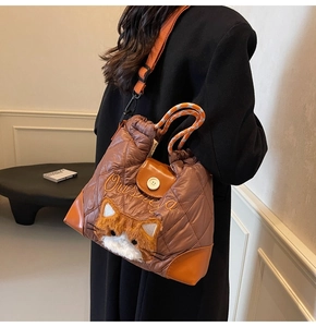 Nahaufnahme der Stepptasche mit Plüschkatze und orangen Nylon-Schultergurten