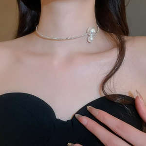 Close-up of elegant silver-colored collar necklace with dual pearls worn by a model