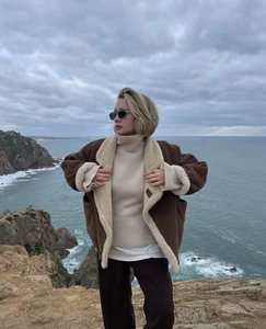 Style urbain en extérieur avec une veste en peau de mouton marron et col roulé beige