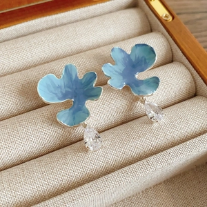 Vue détaillée de boucles d'oreilles fleur bleue avec pierres en forme de gouttelette