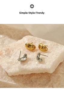 Polished 18K gold and silver bean stud earrings displayed on a natural stone surface