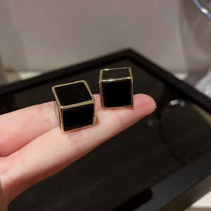 Gros plan de boucles d'oreilles clous géométriques minimalistes noir et doré
