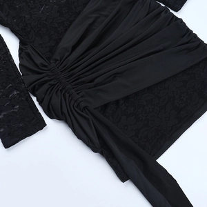 Detail of black lace patchwork and pleated fabric on an off-shoulder slim-fit dress