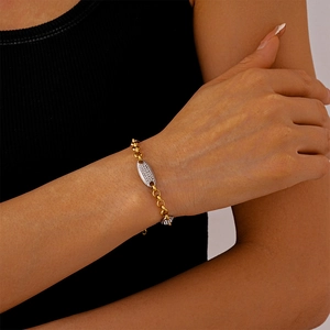 Dettaglio di un bracciale a catena bicolore oro e argento con uno zircone scintillante