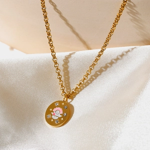 Detalle del collar con colgante ovalado bañado en oro de 18k y motivo de nácar sobre seda