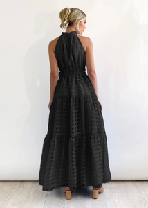Detail of a black plaid sleeveless halter maxi dress with tiered cake-style skirt back view