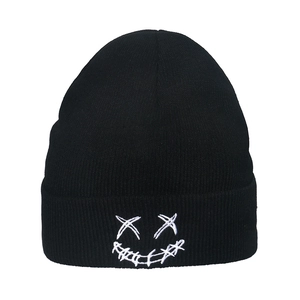 Black knit beanie with white embroidered street style face on a clean white background