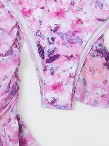 Detailed macro view of oil painting floral print and ruffled edges on swimwear bikini bottom