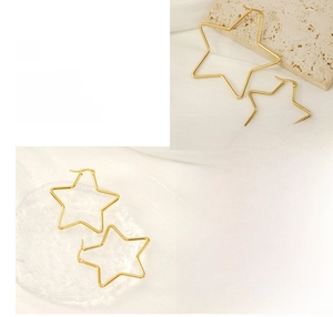 Polished gold star hoop earrings on marble and glass textures showing fine details