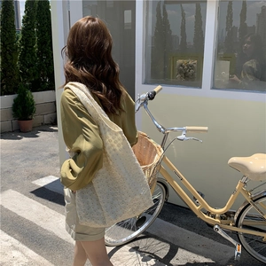 Detailed back view of a white floral lace canvas tote bag worn in a scenic outdoor setting