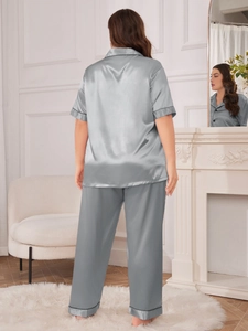 Detail view of silver silk satin pajama set with black piping on collar and sleeves