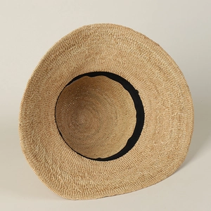 Detailed interior view of handmade raffia sun hat showing tight weave and sweatband