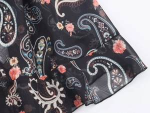 Close-up of chiffon tiered dress sleeve with paisley print and ruffled cuff detail