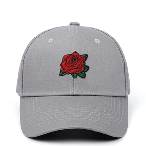 Gros plan d'une broderie de rose rouge sur une casquette de baseball en coton gris