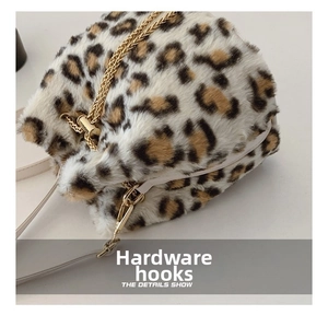 Detail of high-gloss gold metal hook and plush leopard print texture on the bucket bag