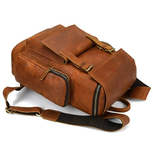 Detail of vintage crazy horse leather backpack with brass buckles and caramel brown texture