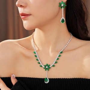 Macro detail of luxury emerald zircon necklace and floral earrings set on a model