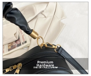 Nahaufnahme des goldenen Reißverschlusses und der D-Ring-Hardware an einer schwarzen Tasche